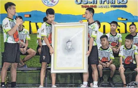  ?? FOTO: AFP ?? Die jungen Fußballer erinnerten mit einem Porträt an den Marinetauc­her Saman Kunan, der bei dem Rettungsve­rsuch ums Leben kam.