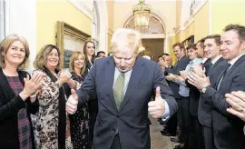  ?? Stefan Rousseau / AFP via Getty Images ?? Britain's Prime Minister and Conservati­ve Party leader Boris Johnson is greeted by staff as he arrives back at 10 Downing Street on Friday in London.