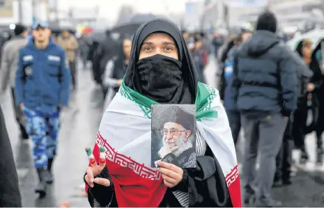  ?? EBRAHIM NOROOZI AP ?? An Iranian woman holds up a portrait of Iranian Supreme Leader Ayatollah Ali Khamenei, as she makes the victory sign during a rally marking the 40th anniversar­y of the 1979 Islamic Revolution, in Tehran, Iran, on Monday. •