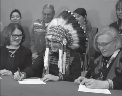  ?? FRED CHARTRAND, THE CANADIAN PRESS ?? Indigenous Services Minister Jane Philpott, far left, and Grand Chief Arlen Dumas, centre, take part in a signing ceremony. Philpott is taking action on root issues such as safe water and high numbers of children in foster care, Tim Harper writes.