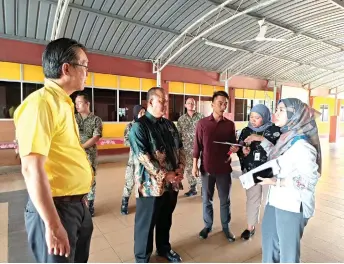  ?? ?? Yap (left) and JKR officers discuss with SK Major General Datu Ibrahim headmaster Ahmad Mustaffa Idris (second left) and PTA representa­tives on the scope of repair works for the school hall.