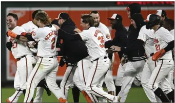  ?? (AP/Nick Wass) ?? Baltimore Orioles catcher James McCann (left), a former Arkansas Razorback, celebrates with shortstop Gunnar Henderson and other teammates after hitting a game-winning two-run single with two outs in the bottom of the ninth inning to defeat the Kansas City Royals 4-3 on Wednesday night at Camden Yards in Baltimore.