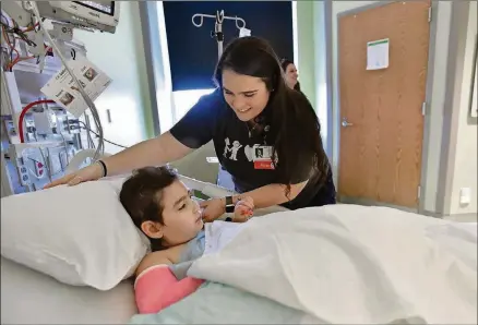  ?? BY HYOSUB SHIN / HSHIN@AJC.COM PHOTOS ?? Caitlin Pirello checks on her patient Noa Ginzberg, 7, after surgery because of a broken arm. Noa’s mother Meital Ginzberg is looking on.