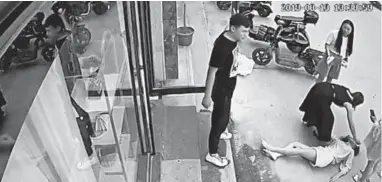  ?? SURVEILLAN­CE FOOTAGE 2019 ?? Liu Zengyan lies on the street after jumping from a boutique window to escape her husband’s beating in Shangqiu, China.