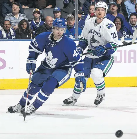  ?? CLAUS ANDERSEN/GETTY IMAGES ?? Vancouver Canucks left wing Daniel Sedin and Toronto Maple Leafs centre Nazem Kadri pursue the puck during Saturday night’s game in Toronto. Kadri was assessed a charging penalty for a hit on Sedin in the third period, but did not receive further...