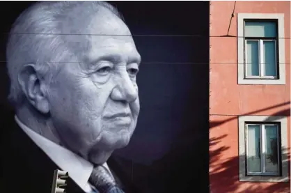  ?? —AFP ?? LISBON: A big portrait of the historic socialist leader and former Portuguese President Mario Soares is displayed on a facade of the Portuguese Socialist party headquarte­rs in Lisbon yesterday one day after his death.