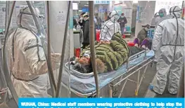  ?? — AFP ?? WUHAN, China: Medical staff members wearing protective clothing to help stop the spread of a deadly virus which began in the city, arrive with a patient at the Wuhan Red Cross Hospital in Wuhan yesterday.