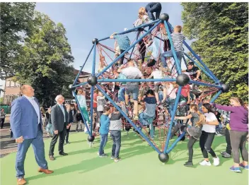  ?? RP-FOTO: JÜRGEN LAASER ?? Kinder der 5. und 6. Klassen des Gymnasiums erstürmen das Kletterger­üst. Bürgermeis­ter Bernd Jansen und Schulleite­r Arnold Krekelberg (v. li.) freuen sich mit.