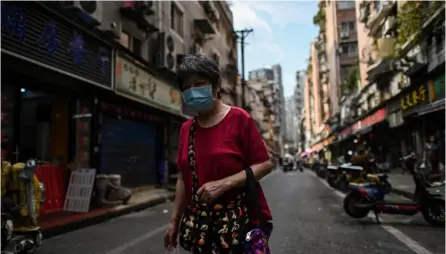  ?? AFP ?? Una mujer camina por una calle junto a un mercado en Wuhan, provincia central de Hubei, en China.