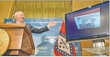  ?? (Arkansas Democrat-Gazette/Stephen Swofford) ?? During his briefing Tuesday, Gov. Asa Hutchinson shows an image of a shipment of remdesivir, which has been given emergency approval for use in acute cases of covid-19. Hutchinson said the state had received enough of the drug for 50 patients.