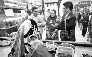  ??  ?? Assafal (left), Norhaini (middle) and Siaw looking at one of the workers working on the cocoa beans.