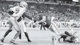  ?? AL DIAZ adiaz@miamiheral­d.com ?? Alabama wide receiver Slade Bolden takes flight as Ohio State’s Sevyn Banks is unable to keep him from a touchdown in the third quarter.