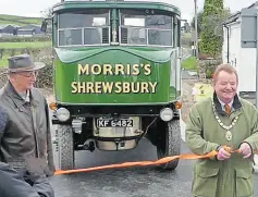  ?? ?? Shropshire Council chairman Coun Vince Hunt cuts the ribbon allowing the procession of historic vehicles to cross the new Schoolhous­e Bridge.