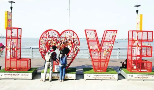  ?? SRENG MENG SRUN ?? A young couple looks at souvenirs at a shop set up for Valentine’s Day on Phnom Penh’s Koh Pich.