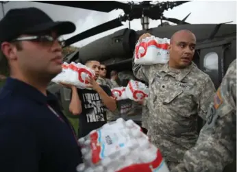 ?? JOE RAEDLE/GETTY IMAGES ?? Members of the Puerto Rican National Guard deliver food and water to hurricane survivors in Lares, Puerto Rico.