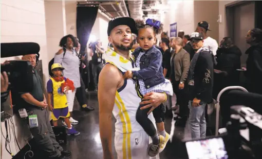  ?? Carlos Avila Gonzalez / The Chronicle ?? Stephen Curry holds his daughter Ryan after a playoff victory over the Rockets in May.