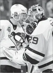  ?? Patrick Smith Getty Images ?? SIDNEY CROSBY congratula­tes goalie Marc-Andre Fleury after his 29-save shutout against the Capitals.