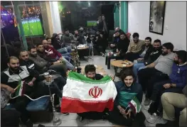  ?? HUSSEIN MALLA — THE ASSOCIATED PRESS ?? Lebanese fans of Iran's team sitting at a coffee shop smoke water pipes, as they watch the World Cup group B match between Iran and the United States, in the Hezbollah stronghold in the southern suburbs of Beirut, Lebanon on Tuesday.