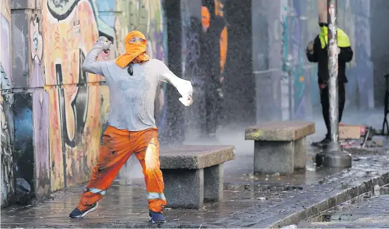  ?? Picture: Reuters ?? Chilean dockworker­s clash with riot police during a protest against the port operator South Pacific Terminal to demand that temporary workers be included in collective bargaining in Valparaiso yesterday.