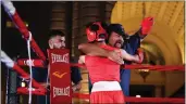  ?? TREVOR STAMP — STAFF ?? Boxing trainer Fausto De La Torre, right, embraces Marvin Gomez, 14, after Gomez won his fight during the Centennial Square Boxing Show in Pasadena in August.