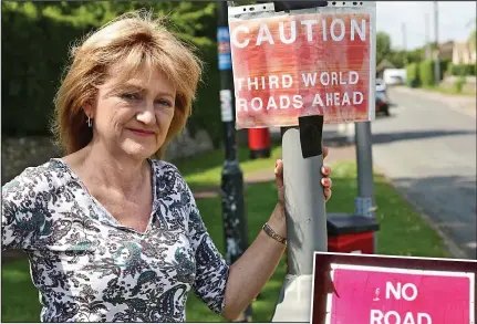  ??  ?? Sign of the times: Angie Abingdon with one of her jokey warnings