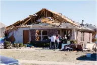  ?? ?? A family gathers in front of their damaged home on Conway Drive on Monday, Feb. 27, 2023 in Norman, Okla. The damage came after rare severe storms and tornadoes moved through Oklahoma overnight. (AP Photo/Alonzo Adams)