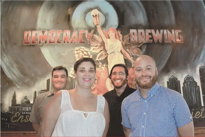  ?? STAFF PHOTO BY CHRIS CHRISTO ?? LIFT A GLASS TO FREEDOM: Jason Taggart, Courtney Bolinger, Ben Waxler and James Razsa, from left, pose by a mural of Lady Liberty at Democracy Brewing.