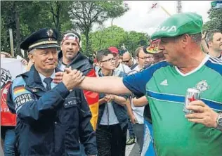  ?? JACKY NAEGELEN / REUTERS ?? Un seguidor nord-irlandès dóna la mà a un policia alemany a París