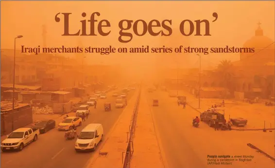  ?? (AP/Hadi Mizban) ?? People navigate a street Monday during a sandstorm in Baghdad.