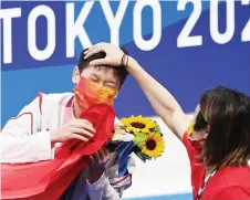  ?? — AFP photo ?? Quan celebrates with a member of the coaching staff.