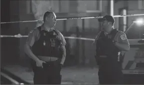  ?? ERIN HOOLEY/CHICAGO TRIBUNE ?? Chicago Police officers work at part of the scene of a shooting on Sunday in the Chatham neighborho­od of Chicago. A 29-year-old man and a 30-year-old man were both shot in the lower body and were taken to Advocate Christ Medical Center in serious...