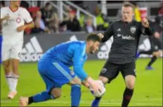  ?? JOHN MCDONNELL — THE WASHINGTON POST VIA AP ?? Toronto FC goalkeeper Alex Bono, left, makes a save in front of D.C. United’s Wayne Rooney Wednesday. Rooney’s free-kick strike gave D.C. a 1-0 win.