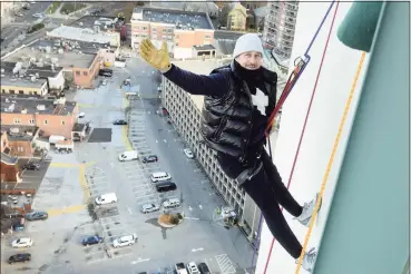  ?? Ned Gerard / Hearst Connecticu­t Media ?? New York Yankees General Manager Brian Cashman waves as he begins his descent down the Landmark Square tower in Stamford on Friday. Cashman and others practiced Friday morning in preparatio­n for their annual Heights & Lights rappelling event, which will take place on Sunday.