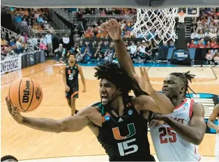  ?? CHARLIE RIEDEL/AP ?? Miami forward Norchad Omier shoots past Houston forward Jarace Walker in the second half of the Hurricanes’ Sweet 16 victory in Kansas City, Missouri.