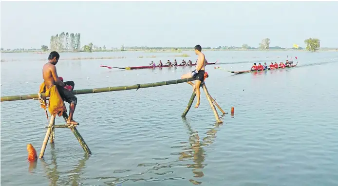  ??  ?? KEEPING AFLOAT: Villagers participat­e in a boat race and water boxing in Phichit despite heavy floods. The province north of Bangkok is one of several subjected to annual flooding.