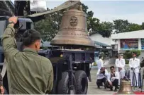  ?? - AFP file photo ?? WAR TROPHY: A local Philippine military personnel unload one of the three Balangiga church bells shortly after it arrived from the US at a military airbase in Manila.