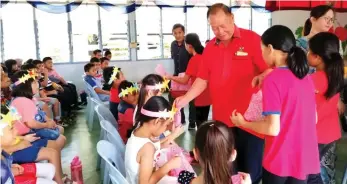  ??  ?? Chairman of school management board of SJK (C) Chin Nam Niah Penghulu Haw Min Wai distribute­s gifts to pupils during Children Day Celebratio­n at the school premises. Some 70 pupils joined the fun-filled event at the school.