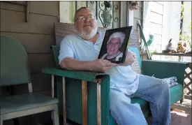  ?? JOHN BAZEMORE — THE ASSOCIATED PRESS ?? James Kelly poses with a photo of his late father also named James Kelly at his home Friday, May 1, Kelly had to delay his plans to travel Scotland, where he planned to scatter his father’s ashes, because of the coronaviru­s outbreak