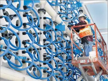  ?? Photograph­s by Don Bartletti Los Angeles Times ?? WORK IS underway on a PoseidonWa­ter desalinati­on plant in Carlsbad, in San Diego County. Now water officials in Orange County are moving toward a deal with Poseidon’s proposed Huntington Beach plant.