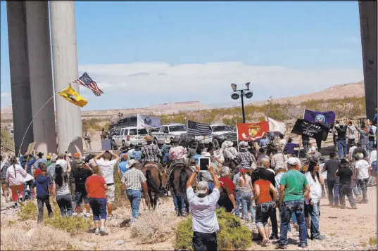  ?? Las Vegas Review-Journal file ?? The Bundy family and their supporters gather under Interstate 15 just outside of Bunkervill­e to confront the Bureau of Land Management and demand the release of the family’s impounded cattle in April 2014.