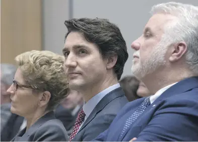  ?? ADRIAN WYLD / THE CANADIAN PRESS ?? Prime Minister Justin Trudeau listens to speakers as he sits with Ontario Premier Kathleen Wynne and Quebec
Premier Philippe Couillard during an informatio­n session at the first ministers meeting in Ottawa Monday.