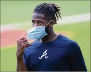  ?? CURTIS COMPTON / CCOMPTON@AJC.COM ?? Pitcher Touki Toussaint adjusts his face mask before an intrasquad game as the Braves and other teams prepare for baseball’s return. So far, early testing in pro leagues has looked promising.