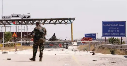  ?? File / Reuters ?? A Syrian soldier walks as he holds his weapon at the Naseeb border crossing with Jordan in Deraa.