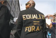  ??  ?? Joe Houston wears his sentiments prominentl­y as he heads to Yerba Buena Gardens during the annual King Day march.