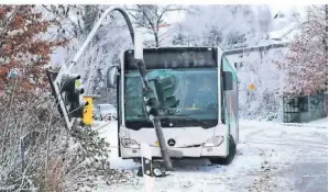  ?? FOTO: DPA ?? In Herdecke ist ein Schulbus auf schneeglat­ter Straße gegen eine Ampel gefahren. Pendlern wurde am Donnerstag viel Geduld abverlangt.