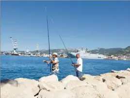  ?? (Ph. Régine Meunier) ?? Francis avec le chapeau et François, compagnons de pêche du bord à Toulon, se demandent comment faire la soupe de poisson ou la friture si les poissons ne sont pas petits. Pourtant, Pierre Gilles de l’Institut océanograp­hique-Albert er rappelle qu’il existe une réglementa­tion sur la taille des prises.