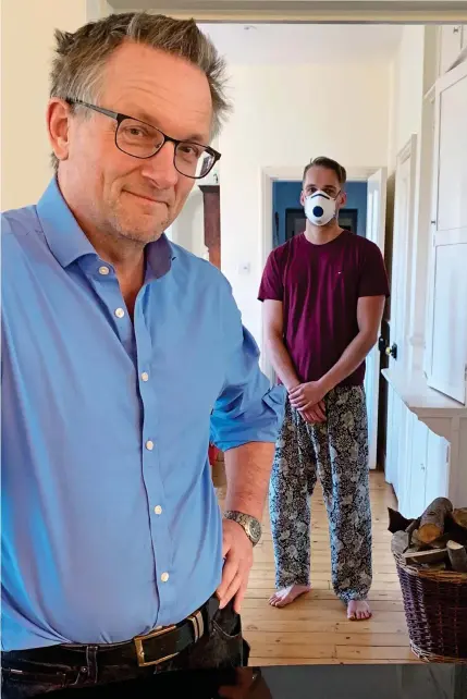  ??  ?? KEEPING THEIR DISTANCE: Michael Mosley at home with his son Dan, who is recovering from the virus