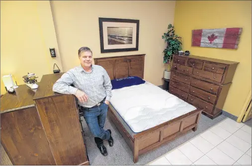  ?? CP PHOTO ?? Mike Cleaver poses with a new waterbed at his mattress store in Barrie, Ont.