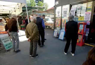  ??  ?? Residenti dell’Isolotto ieri davanti all’edicola in piazza del mercato A sinistra la «locandina» dell’edicolante