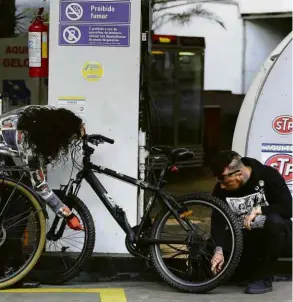  ?? Nelson Antoine/Folhapress ?? Sem combustíve­l, casal enche pneu de bicicletas em posto